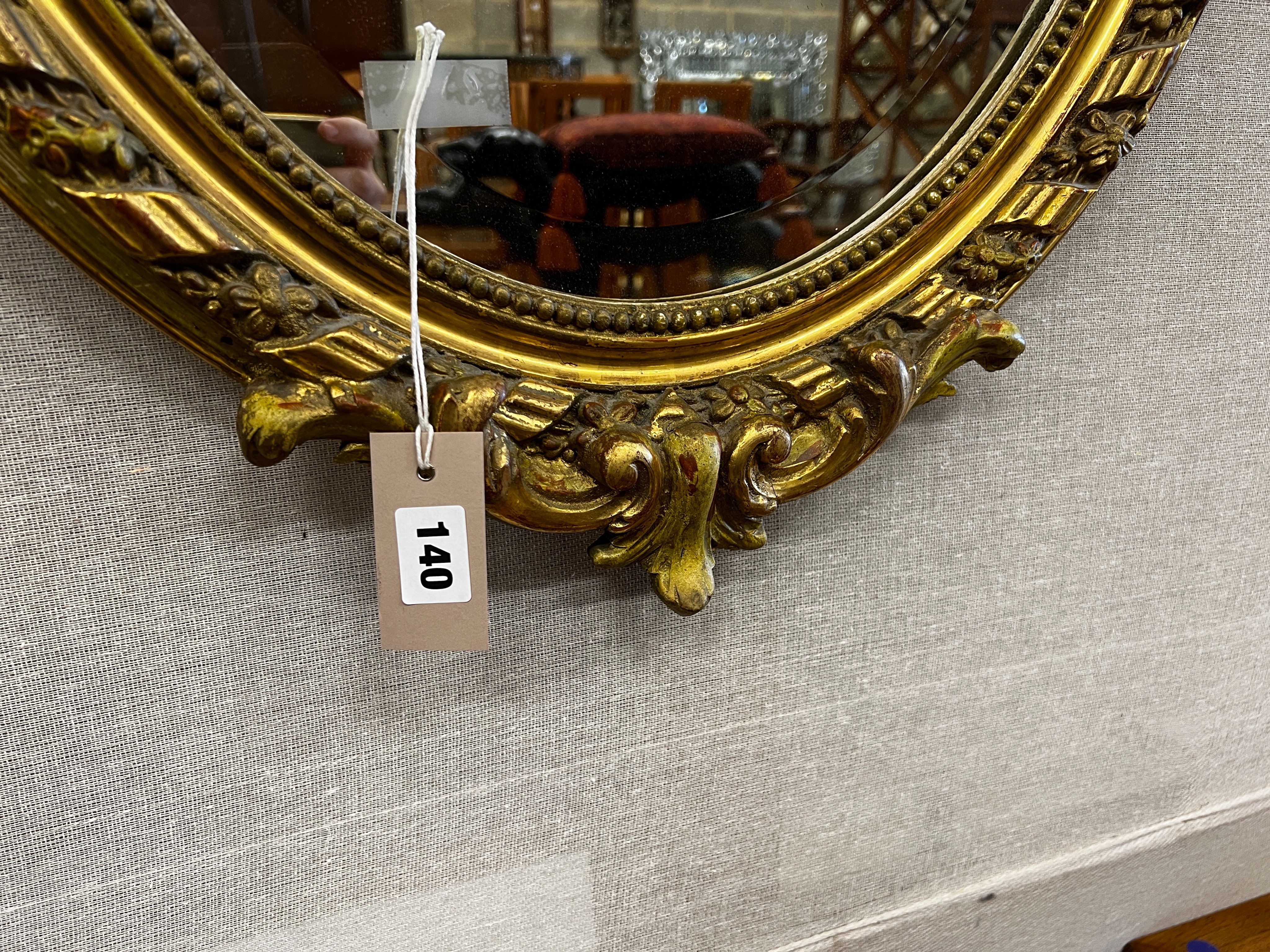 A 19th century French giltwood and composition oval wall mirror with pierced scrolling pediment, width 54cm, height 82cm